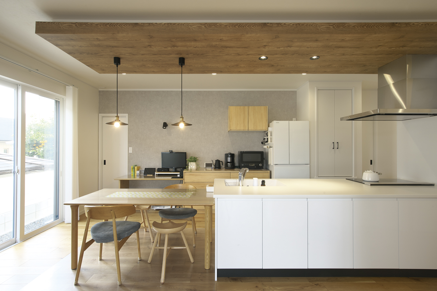 木目クロスの下がり天井とキッチン横並びダイニング