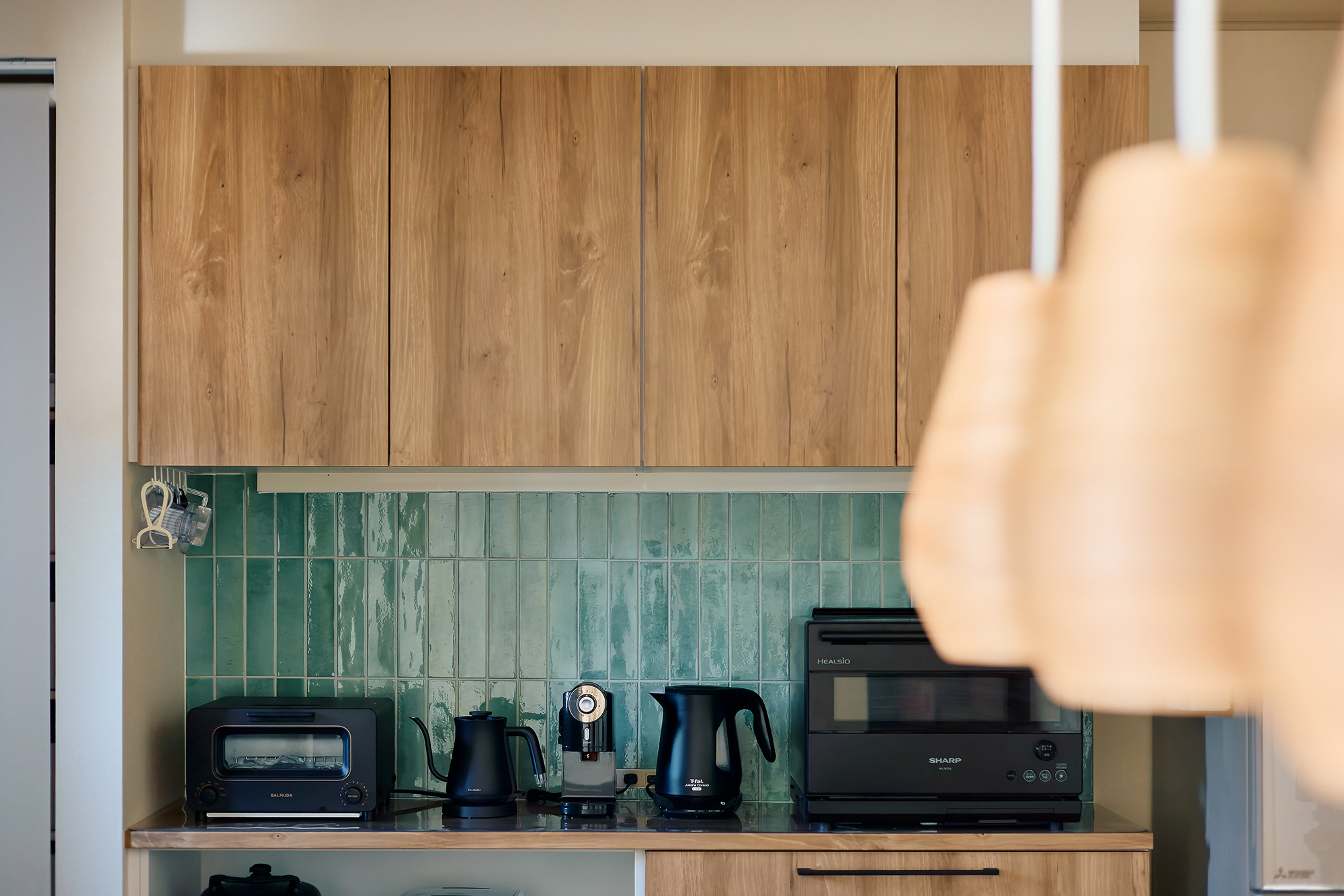 緑のタイルが鮮やかなアクセントのキッチン