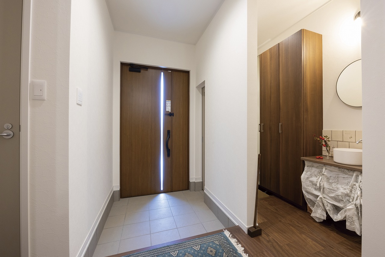 タイルをはった手洗いボウルのある玄関