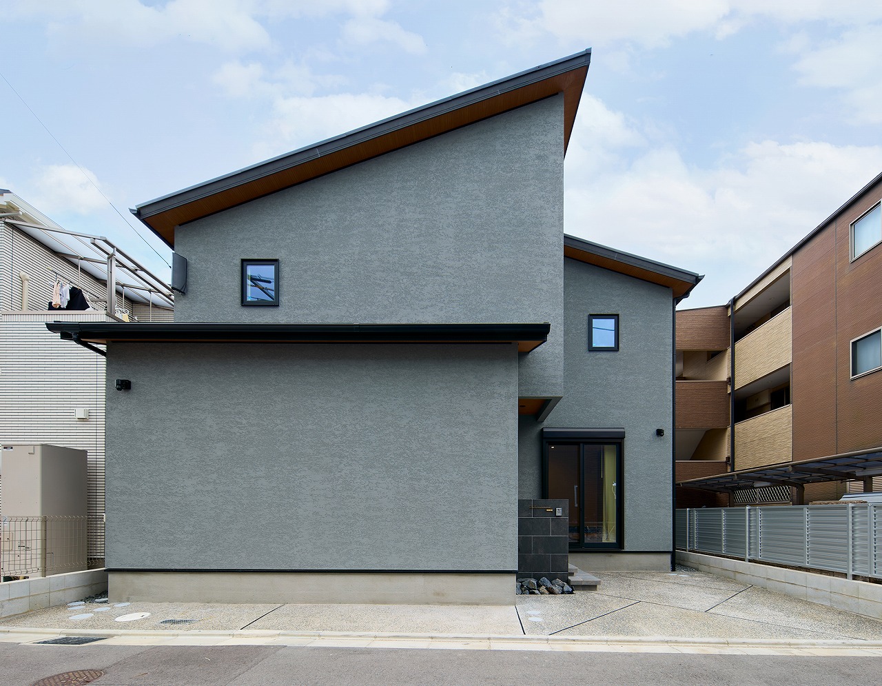 グレーの外壁と木目の軒裏が特徴の注文住宅の外観